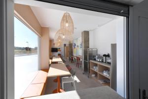 a room with tables and chairs and a large window at Moebius - Habitaciones privadas con baño in León