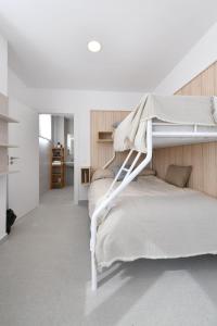 a white bedroom with a bunk bed with a ladder at Moebius - Habitaciones privadas con baño in León +51 photos