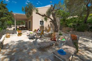 a patio with chairs and a tree in a yard at KATINA COTTAGE in Kontogiannátika