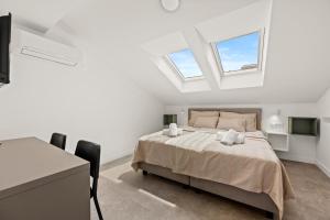a white bedroom with a bed and two windows at Calypso Residence 3 in Umag