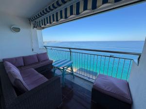 a balcony with a couch and a view of the ocean at Аpartamentos en primera línea de mar in Platja  d'Aro