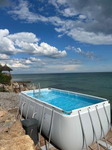 a swimming pool with the ocean in the background at Отдых у моря in Nova Dofinivka