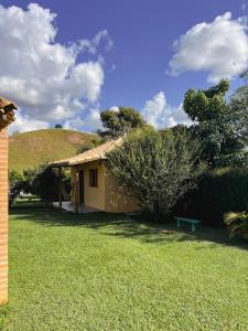 a small house with a green hill behind it at Hospedagem Fernandes Cunha, SP in Cunha