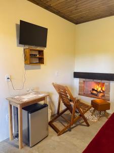 a living room with a table and a fireplace at Hospedagem Fernandes Cunha, SP in Cunha