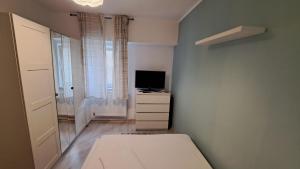 a small bedroom with a bed and a television at Apartament Lara in Constanţa