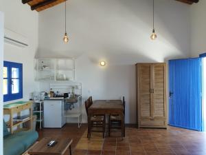 a living room with a table and a kitchen at 2P studio in Skiathos