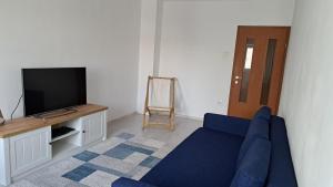 a living room with a blue couch and a tv at Apartament Lara in Constanţa +4 photos