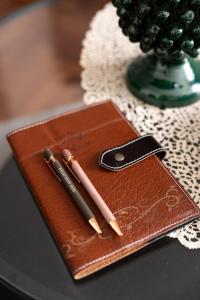 two pens sitting on top of a brown wallet at Teddy House Ortigia in Syracuse +37 photos