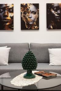 a green plant on a glass table in front of a couch at Teddy House Ortigia in Syracuse