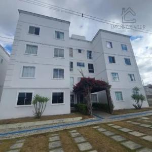 un gran edificio blanco con plantas delante en Apart no condomínio Residencial Ipojuca, en Caruaru