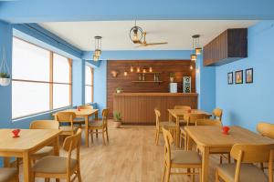 una sala da pranzo con tavoli e sedie in legno di Casa D Village Wing 2 in Goa a Goa