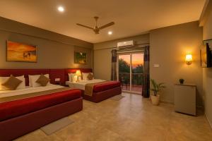 una camera d'albergo con due letti e un divano di Casa D Village Wing 2 in Goa a Goa Altre 24 foto