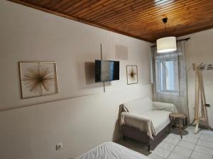 a living room with a chair and a tv on the wall at Old Town's Nest in Corfu