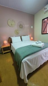 a bedroom with two large beds with green sheets at Ypê Hospedagem in Sao Jorge