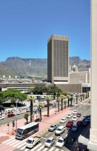ruchliwa ulica miejska z samochodami zaparkowanymi przed budynkiem w obiekcie Capetown City Living 1Bedroom Stay at Foreshore Place w Kapsztadzie