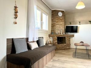 a living room with a bed and a fireplace at Cottage near the sea in Nea Moudania