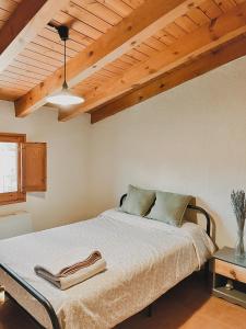 a bedroom with a bed and a wooden ceiling at Alberg rural torre del baró in Sant Llorenc de Morunys