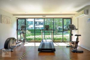a gym with three treadmills and a large window at Centrio 2 bed rooms in Ban Nong Chaeng
