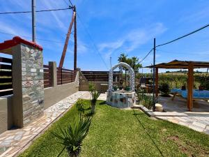 a garden with a fountain in the middle of a yard at Cottage near the sea in Nea Moudania