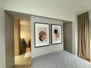 a bedroom with three framed pictures on the wall at Cozy Studio Sulina in Sulina