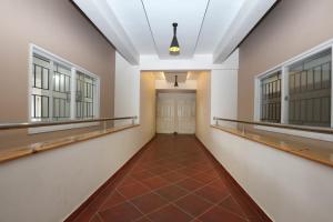 BelagulaSuper Hotel O Indra Comforts的一条带窗户和瓷砖地板的空走廊