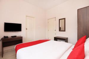 BelagulaSuper Hotel O Indra Comforts的卧室里有一张白色的床和一台电视