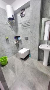 a bathroom with a white toilet and a sink at Mendo Dhim Homestay in Gangtok