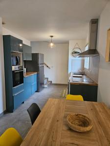 a kitchen with a wooden table and yellow chairs at Nid Douillet Climatisée ''MEETT - Aéroscopia - TRAMWAY'' in Aussonne