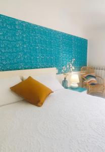 Un dormitorio con una cama blanca y una pared azul. en Casa Milo, en Deiva Marina