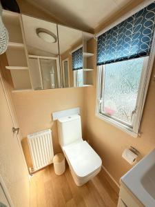 a small bathroom with a toilet and a window at Skigh Cabin in St. Andrews +14 photos