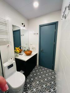 a bathroom with a toilet and a blue door at Bakuriani Bliss Apartment in Bakuriani +21 photos