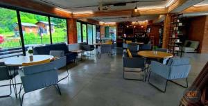 a restaurant with tables and chairs and windows at Bakuriani Bliss Apartment in Bakuriani