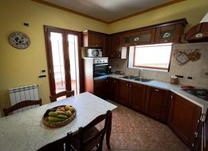 a kitchen with a table with a bowl of fruit on it at Attico in Cefalù