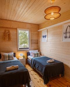 two beds in a room with wooden walls at Rafa Międzywodzie in Międzywodzie