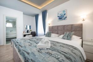 a bedroom with a large bed with towels on it at Luxury Rooms Floramye in Split +22 photos
