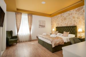 a bedroom with a large bed with a stone wall at Luxury Rooms Floramye in Split