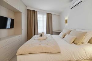 ein Schlafzimmer mit einem großen Bett und einem TV in der Unterkunft Chic 2BR 4P Apartment Saint-Tropez Lices in Saint-Tropez