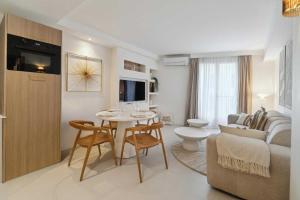 ein Wohnzimmer mit einem Tisch und ein Wohnzimmer mit einem Sofa in der Unterkunft Chic 2BR 4P Apartment Saint-Tropez Lices in Saint-Tropez