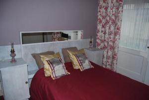 een slaapkamer met een rood bed met kussens en een raam bij Villa Paul in Blankenberge