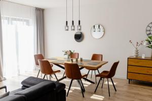 a living room with a dining room table and chairs at Baltic Harmony Villas - Grzybowo in Grzybowo