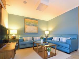 uma sala de estar com um sofá azul e uma mesa em Apartamento en la Isla de la Toja em Isla de la Toja