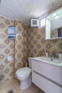 a bathroom with a toilet and a sink and a mirror at Sunrise Pefkochori in Pefkohori