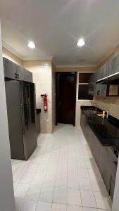 a kitchen with a refrigerator and a tile floor at Muzn al Khareef مزن الخريف in Salalah +17 photos