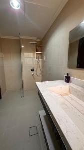a large bathroom with a shower and a sink at Muzn al Khareef مزن الخريف in Salalah