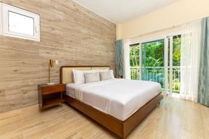 拉斯特拉纳斯Luxury Beachfront 2BR Apt -Prime Location in Playa Bonita的一间带床和大窗户的卧室