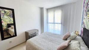ein weißes Schlafzimmer mit einem Bett und einem Fenster in der Unterkunft BEACH VALENCIA LUXURY A36-22 Apartment with terrace and sea views in Valencia