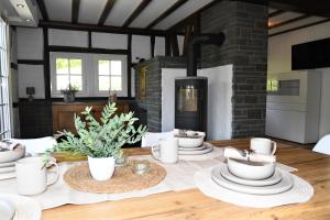 a dining room with a table with a fireplace at Ferienhaus Rurberger Ruhe in Simmerath