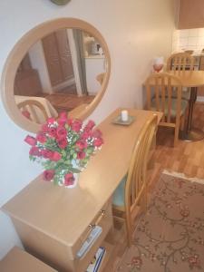 a table with a vase of flowers and a mirror at Yksiö upealla järvinäkymällä Termessä in Ikaalinen +4 photos