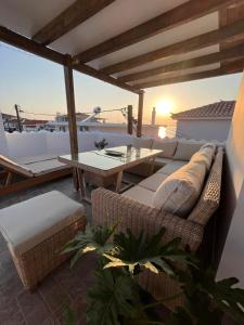 a patio with a couch and a table on a roof at Maroulios Apartment in Elafonisos