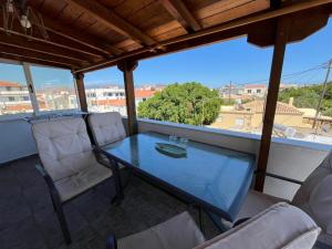 a table and chairs on a balcony with a view at Maroulios Apartment in Elafonisos